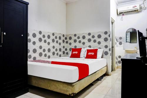 a bedroom with a bed with red pillows on it at Hotel O Royani Residence in Jakarta