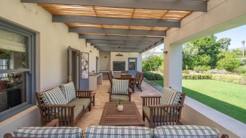 a patio with chairs and a table on a porch at Vygievlei in McGregor