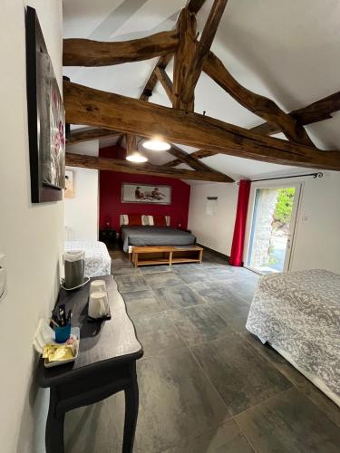 Un dormitorio con 2 camas y una mesa en una habitación en Au Petit Bignon, en Les Épesses