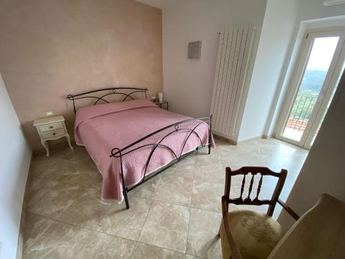 a bedroom with a pink bed and a chair at B&B La Voce della Luna in San Vito Chietino