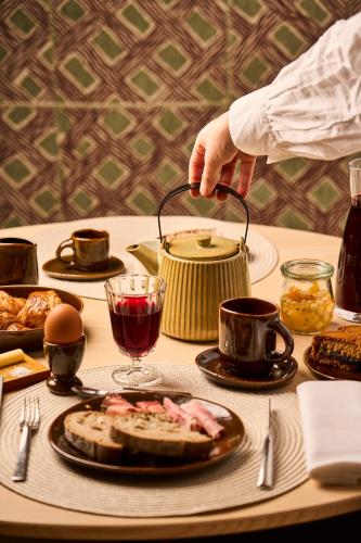 a person is pouring food into a pot on a table at Hostellerie Du Chapeau Rouge in Dijon