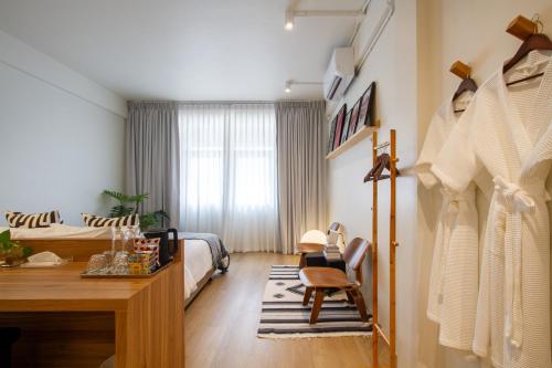 a bedroom with a bed and a desk and a table at Dear Sunday Hometel Bangkok in Bangkok
