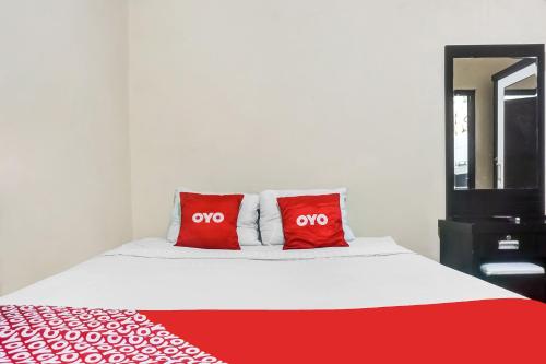 a bedroom with two red pillows on a bed at Hotel O 59 Residence in Jakarta