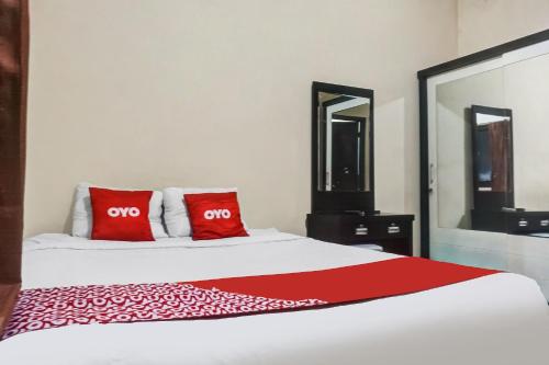 a bedroom with a bed with two red pillows at Hotel O 59 Residence in Jakarta