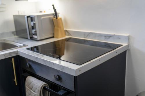 a kitchen with a sink and a microwave at Greenside Getaway in Newarthill