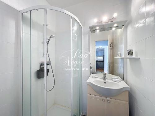 une salle de bain blanche avec un lavabo et une douche dans l'établissement Appartement T2, 4 personnes terrasse vue mer résidence avec piscine à Pramousquier - LE LAVANDOU, au Lavandou