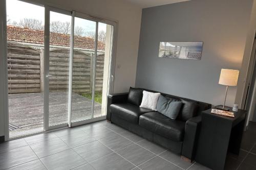 a living room with a black couch and a sliding glass door at Beautiful 2-bedroom family home in Lanton
