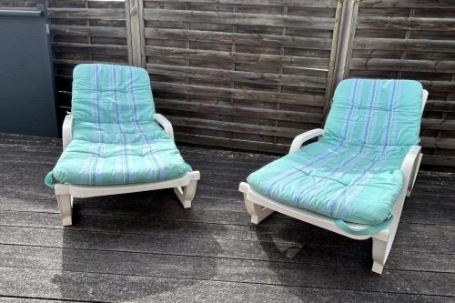 two chairs with blue cushions sitting next to each other at Beautiful 2-bedroom family home in Lanton