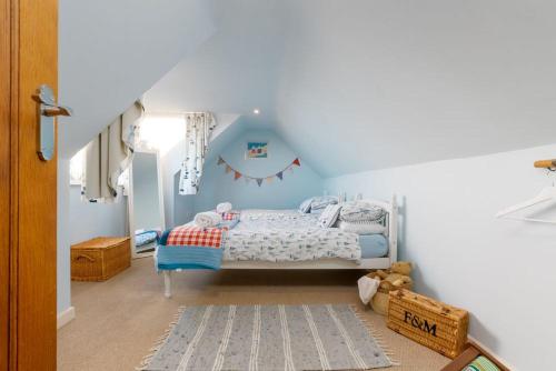een slaapkamer met een bed in een blauwe kamer bij Littlecot in Weymouth