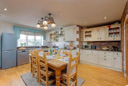 a kitchen with a table and chairs and a refrigerator at Littlecot in Weymouth