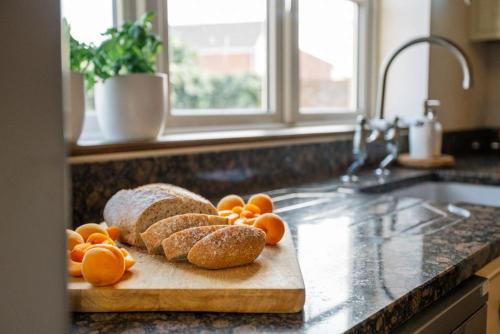 een snijplank met brood en sinaasappels op een aanrecht bij Littlecot in Weymouth