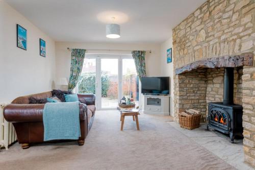 a living room with a couch and a stone fireplace at Littlecot in Weymouth