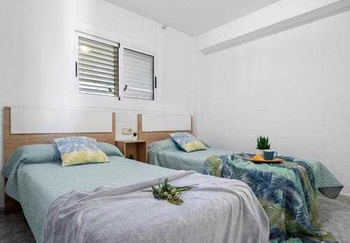 una habitación con dos camas y una ventana en Apartamento Bell Raco, en La Pineda