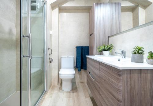 Un baño con inodoro y ducha de cristal. en Apartamento Bell Raco, en La Pineda