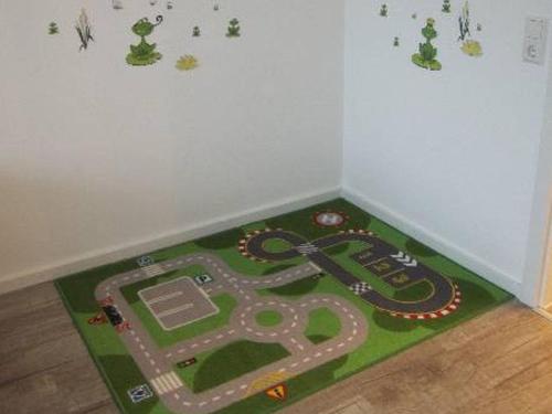 ein Teppich mit Spielsachen in einer Ecke eines Zimmers in der Unterkunft Ferienwohnung Bäumchen in Höchenschwand