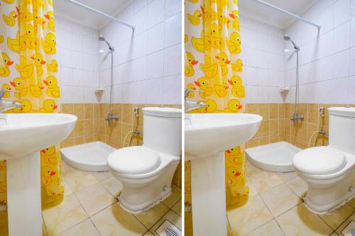 a bathroom with two sinks and two toilets in a room at OYO 124 Al Salam Palace Hotel in Manama