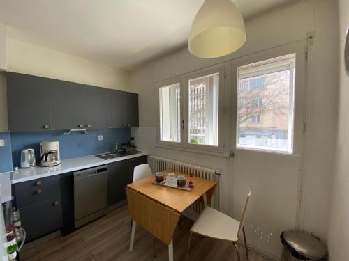 une cuisine avec une table en bois et une table et des chaises dans l'établissement Le Nook ¤ Nid cosy à 600m de la vieille ville ¤, à Annecy