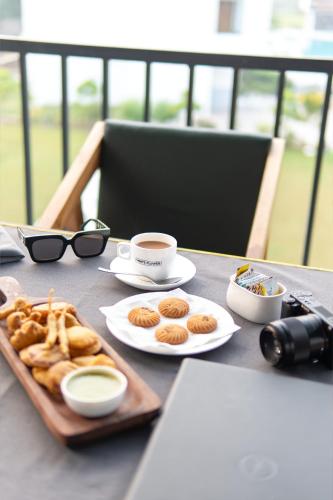 a table with a tray of pastries and a cup of coffee at Corbett Tusker Meadows by White Flower in Rāmnagar