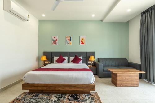 a bedroom with a large bed and a couch at Corbett Tusker Meadows by White Flower in Rāmnagar