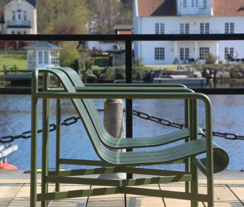 a green chair chained to a table by the water at Åhus Gästgivaregård in Åhus