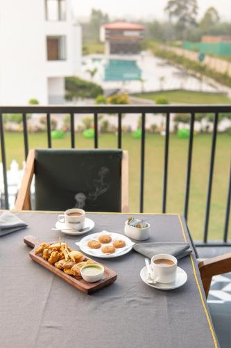 a table with a tray of food and cups of coffee at Corbett Tusker Meadows by White Flower in Rāmnagar