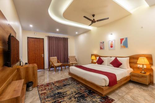 a hotel room with a bed and a television at Corbett Tusker Meadows by White Flower in Rāmnagar