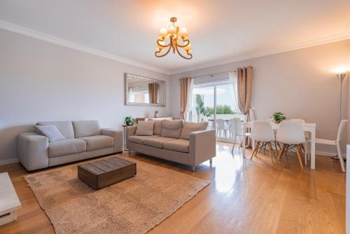 a living room with a couch and a dining room at Real Oeiras Residence in Paço de Arcos