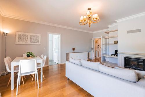 a living room with a couch and a table at Real Oeiras Residence in Paço de Arcos