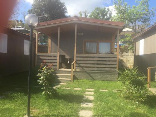 a small house with a porch and a yard at Campeggio Haway in Viverone