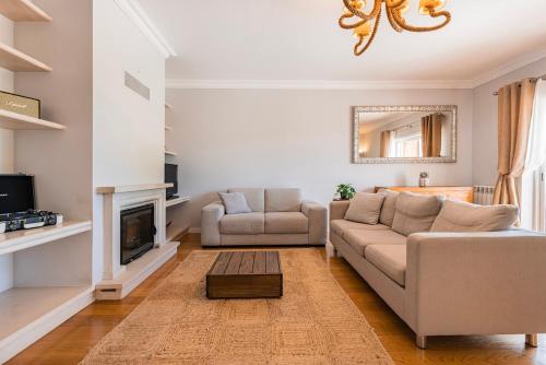 a living room with a couch and a fireplace at Real Oeiras Residence in Paço de Arcos