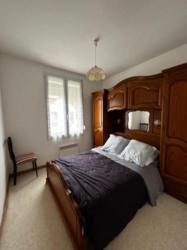 - une chambre avec un grand lit en bois et une fenêtre dans l'établissement Val 1er, à Quend-Plage