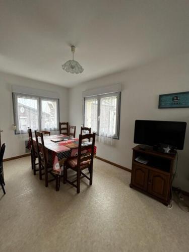 une salle à manger avec une table et une télévision dans l'établissement Val 1er, à Quend-Plage
