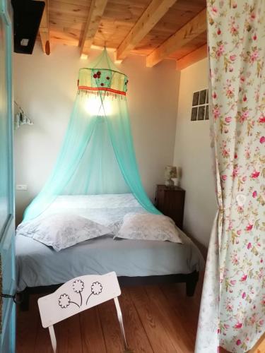 - une chambre avec un lit à baldaquin bleu dans l'établissement L atelier de PELLICA, à Lit-et-Mixe