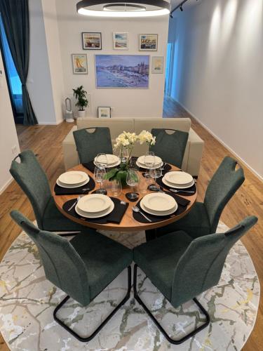 een eettafel met groene stoelen en een tafel met een stoel bij Premium Apartment Koper in Koper