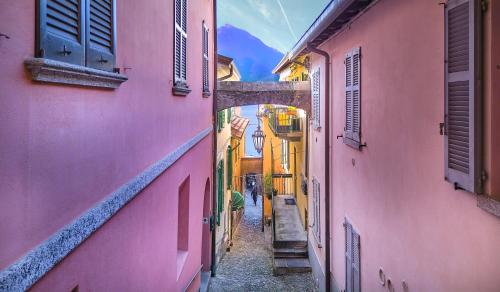 an alleyway between two pink buildings in a city at Varenna Boulevard in Varenna