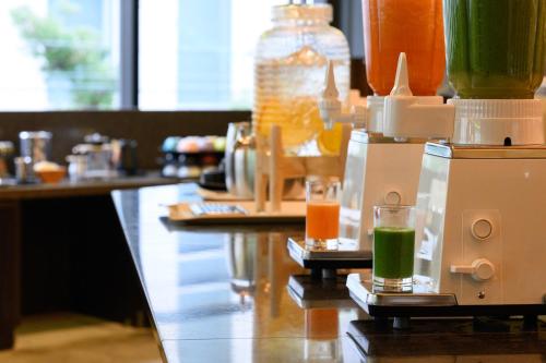 a bar with two glasses of juice on a counter at The Royal Park Canvas - Osaka Kitahama in Osaka