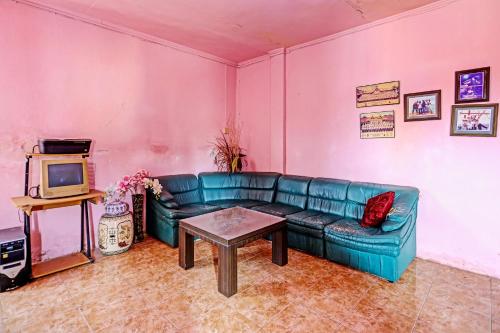 a living room with a blue couch and a table at Hotel O Duta Stay in Tanjung Pinang 