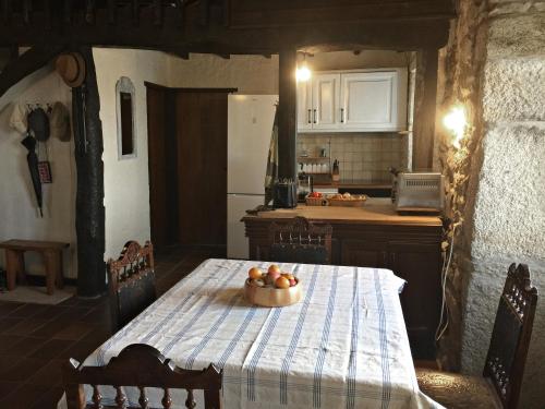 a kitchen with a table with a bowl of fruit on it at La casita de piedra in Porto do Son