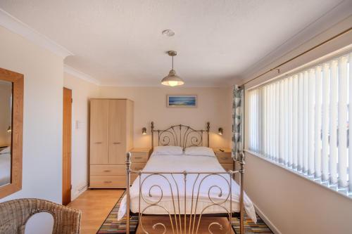 ein Schlafzimmer mit einem Bett und einem Fenster in der Unterkunft Mermaid - Pet Friendly Self Catering Holiday Cottage Hayle in Hayle
