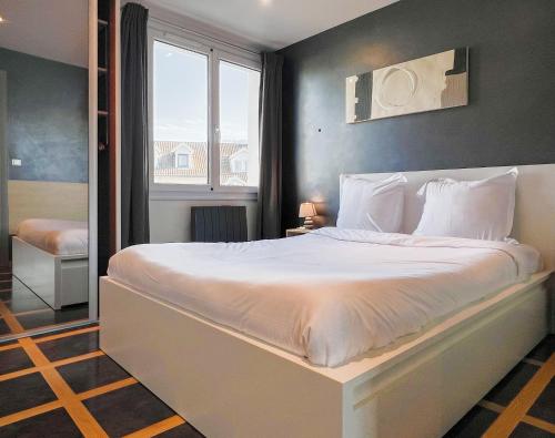 un grand lit blanc dans une chambre avec une fenêtre dans l'établissement Imperial Ember 2 min du lac, à Annecy