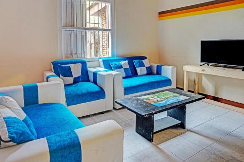 a living room with blue couches and a tv at OYO Life 91452 Ngajeng Peken Homestay in Batu
