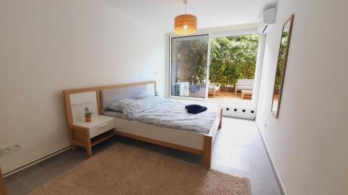 une chambre avec un lit et une grande fenêtre dans l'établissement T3 double terrasses CLIM WIFI en Centre-ville - ROSSIconciergerie - Linge inclus, à La Grande Motte