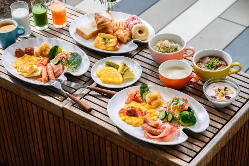 a wooden table topped with plates of breakfast foods at The Royal Park Canvas - Osaka Kitahama in Osaka
