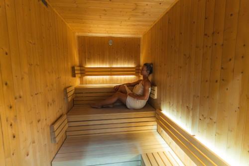 a woman sitting in the inside of a sauna at Miracle Seasons in Liptovský Mikuláš