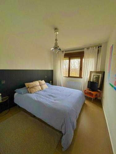 a bedroom with a large bed and a window at Casa Rural Teja Vieja in Duruelo