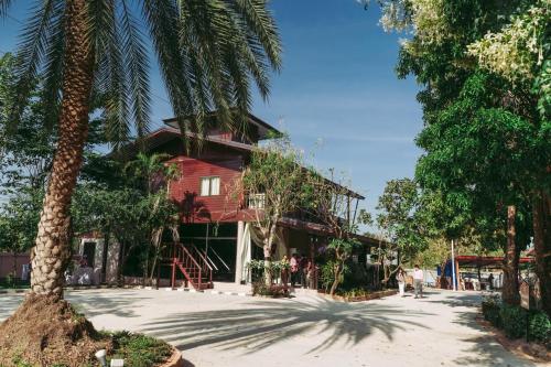 a house with a palm tree in front of it at ชลธี รีสอร์ท in Maha Sarakham