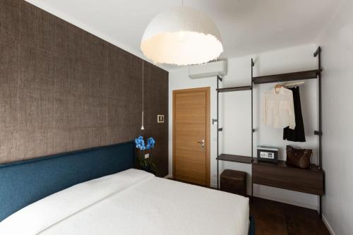 a bedroom with a white bed and a large light fixture at Sunset Room&Breakfast in Grado