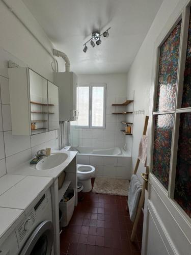 une salle de bain avec un lavabo, des toilettes et une baignoire dans l'établissement Appartement situé en plein coeur de Paris, à Paris