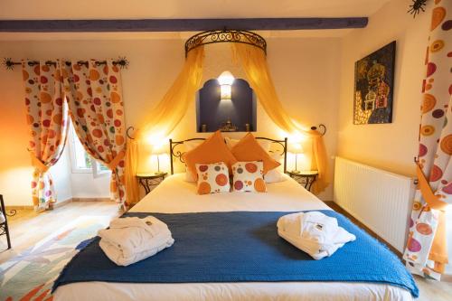 a bedroom with a large bed with towels on it at Le Moulin de Beaunette in Grane