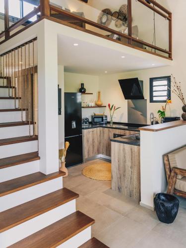 a kitchen and living room with stairs and a counter at Domaine du Cap Sauvage in Saint-Joseph